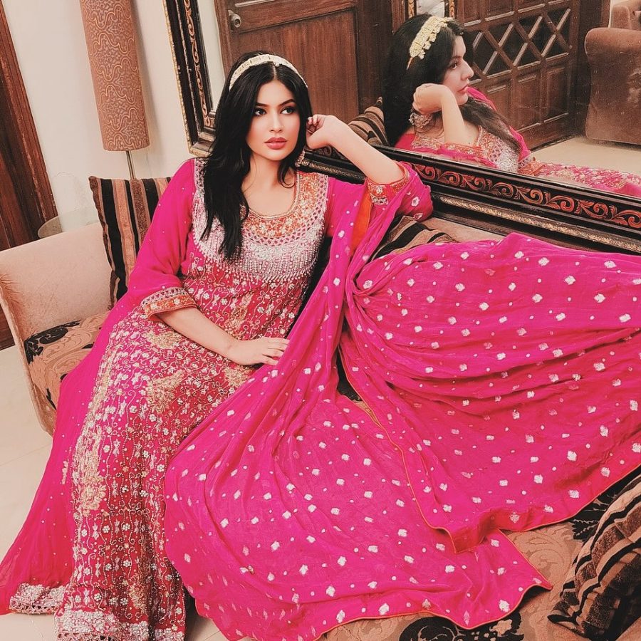 "A stunning shocking pink long maxi dress adorned with intricate embroidery and sequins.